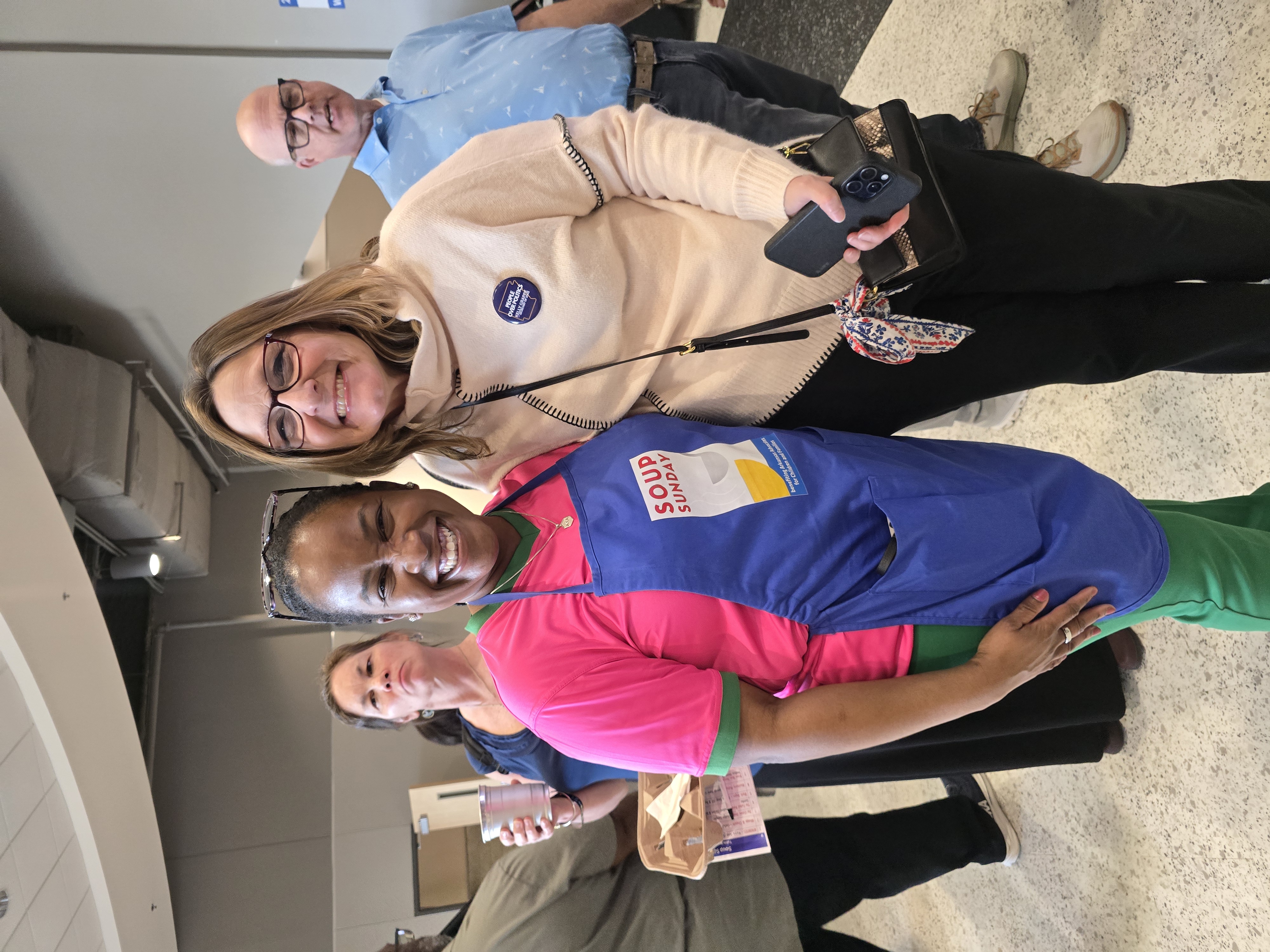 Kelly Grappe smiles beside a volunteer in a Soup Sunday apron benefiting Arkansas Advocates for Children and Families.