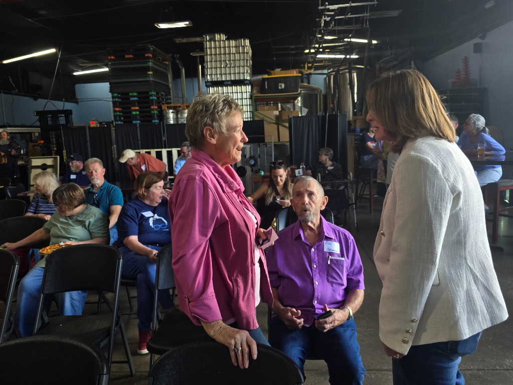 Kelly Grappe for Arkansas Secretary of State — campaign photo Kelly Grappe, candidate for Arkansas Secretary of State. Kelly Grappe talks with community members at a brewery meet-and-greet.