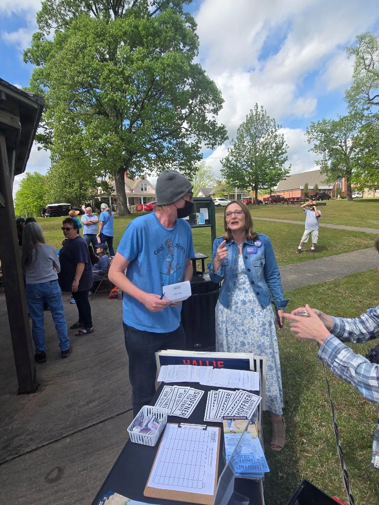 Kelly Grappe speaks with a voter at a campaign information table during a community meet-and-greet in Mena, Arkansas.