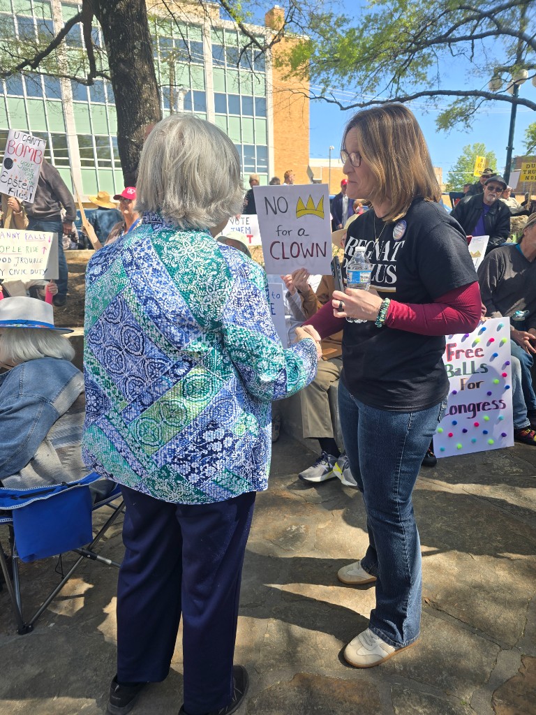 Kelly Grappe for Arkansas Secretary of State — greets a neighbor with a handshake at an outdoor rally Kelly Grappe, candidate for Arkansas Secretary of State, greets a neighbor with a handshake at an outdoor rally.