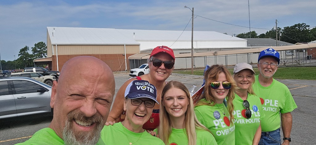 Kelly Grappe for Arkansas Secretary of State — stands with supporters in People Over Politics shirts Kelly Grappe, candidate for Arkansas Secretary of State, stands with supporters in People Over Politics shirts.