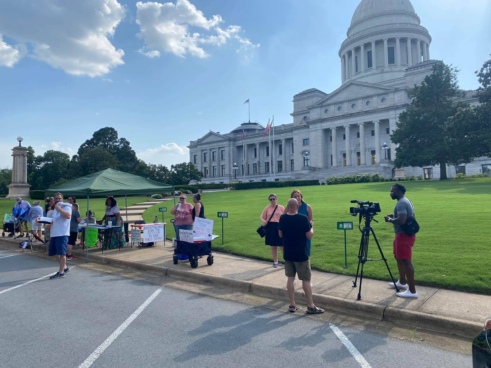 Kelly Grappe for Arkansas Secretary of State — campaign photo Kelly Grappe, candidate for Arkansas Secretary of State. Neighbors and a petition table on the Arkansas State Capitol grounds, with the Capitol dome behind them.