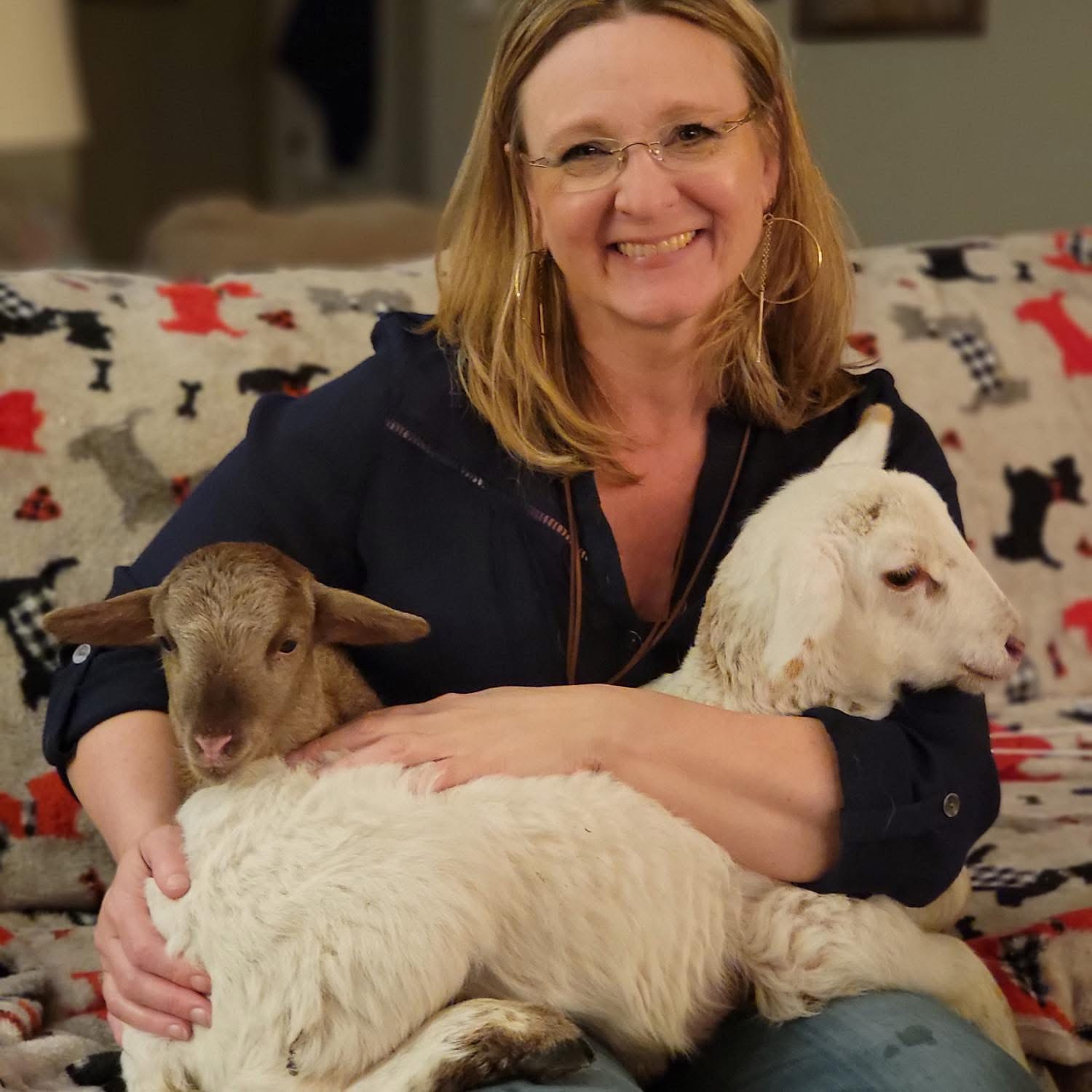 Kelly Grappe for Arkansas Secretary of State — campaign photo Kelly Grappe, candidate for Arkansas Secretary of State. Kelly Grappe sits at home holding two young goats.